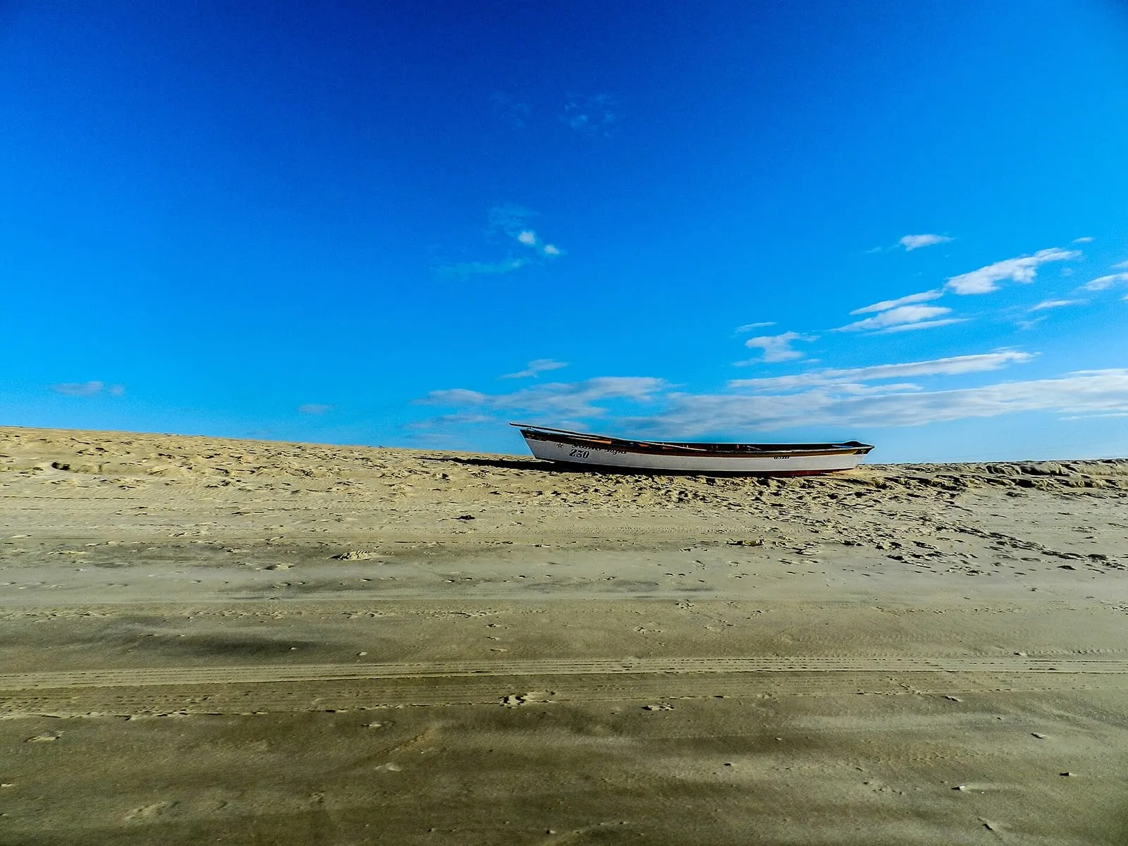 Duna e barco na península de Galinhos