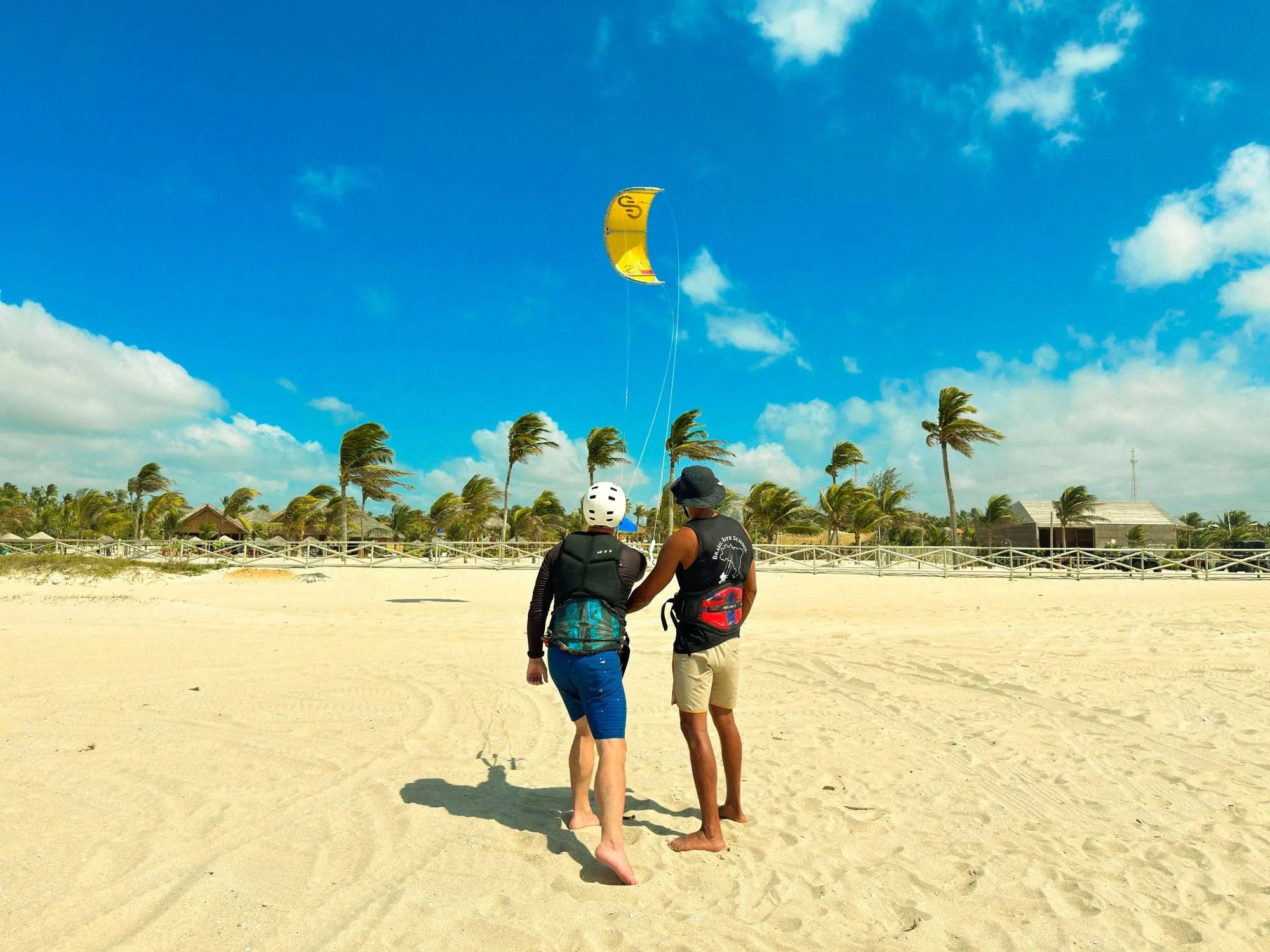 Instrutor e aluno controlando o kite na areia em Jericoacoara